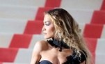 A cantora, compositora e atriz Rita Ora usa vestido com decote sensual e detalhes transparentes.  Na imagem, ela posa para fotógrafos na escadaria que dá acesso ao tapete vermelho.