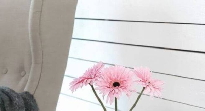 A gérbera rosa sobre o criado mudo decora o ambiente