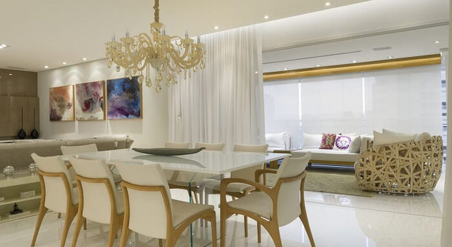 A mesa retangular da sala de jantar se integra ao ambiente da varanda