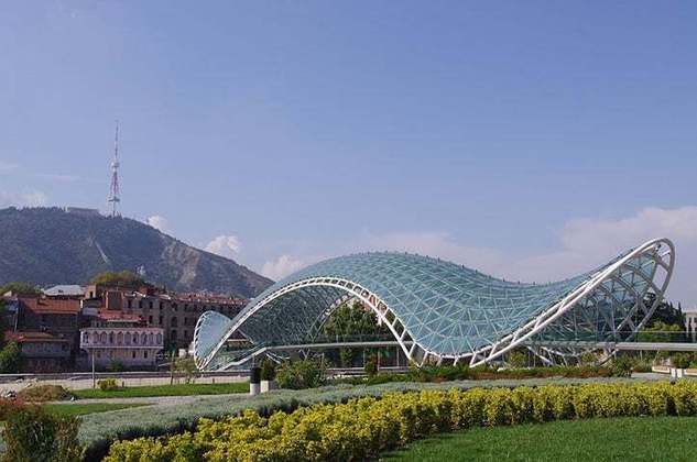 A Ponte da Paz, em forma de arco, é uma construção de aço e vidro iluminada com vários LEDs, sobre o rio Kura, ligando o Parque Rike com a cidade velha no centro de Tbilisi.