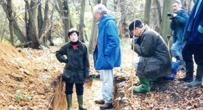 A professora Patricia Wiltshire entre quatro homens fotografando no meio da floresta