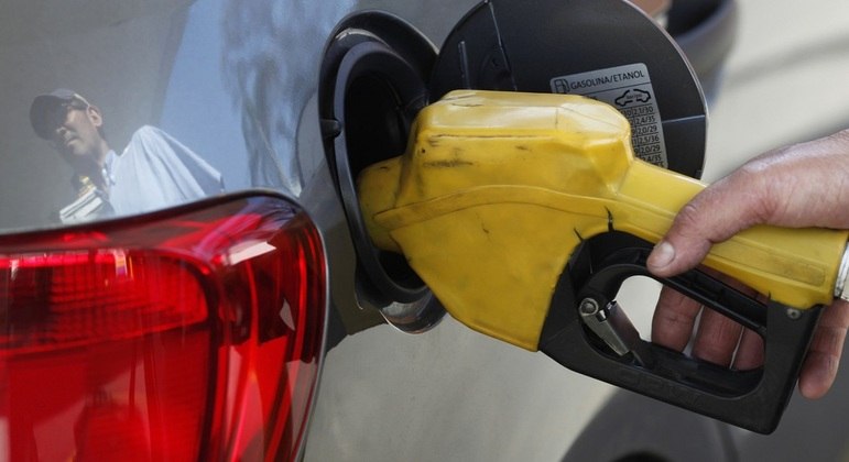 Pessoa abastece o carro em posto de combustível