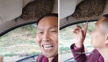 Motorista mantém a calma e a felicidade enquanto dirige com enxame de abelhas no teto do carro