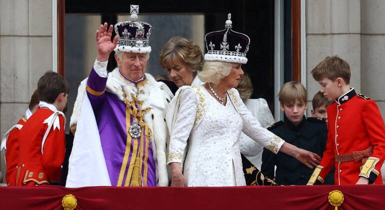 Charles 3º, junto da família real, acena para o público no balcão do Palácio de Buckingham