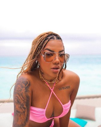 Quando esteve nas Maldivas, Ludmilla usou um biquíni rosa com um conjunto de colares dourados, brinco de argola prata e óculos de sol de lentes quadradonas