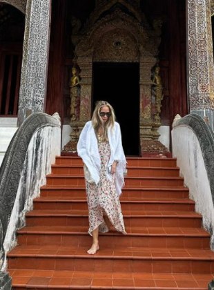 Que tal um figurino meio hippie, meio romântico? Adriane conseguiu essa combinação de estilos ao usar um vestido longo com estampa floral, echarpe branca e colar 