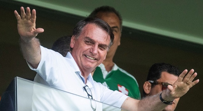 Bolsonaro acena para o público durante partida de futebol