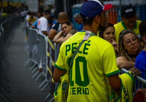 As longas filas atraem os vendedores ambulantes, que tentam vender uma lembrança da despedida de Pelé
