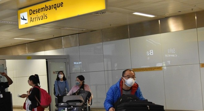 Passageiros usam máscaras no Aeroporto Internacional de Guarulhos