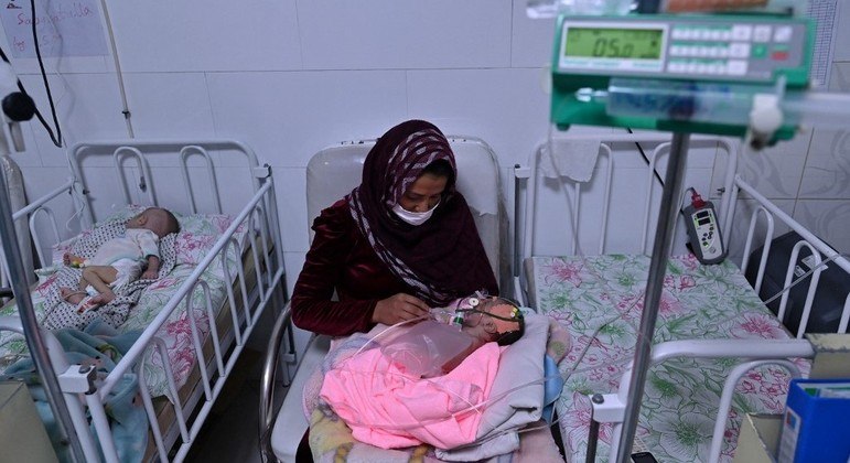 Mulher segura seu bebê que sofre de desnutrição, em clínica no Afeganistão