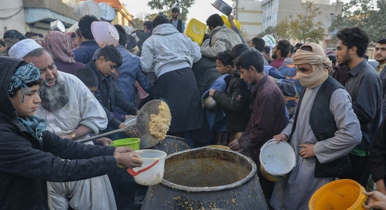 Pessoas destribuem comida na cidade de Herat, no Afeganistão