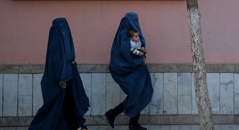 Mulheres vestidas com burcas caminham em Cabul, no Afeganistão