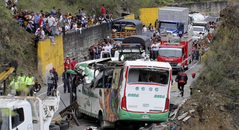Equipes de resgate protegem um ônibus de cair de um barranco após um acidente na Rodovia Panamericana