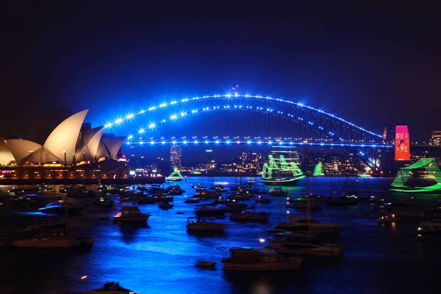 The Sydney Opera House (L) and Harbour Bridge are lit up ahead of the New Year's Eve fireworks display in Sydney on December 31, 2022. 