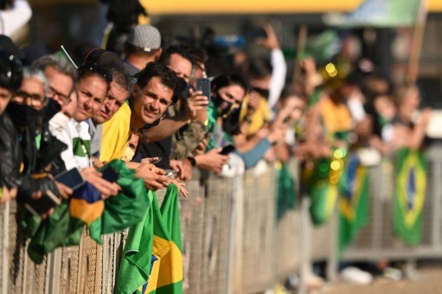 Supporters of Brazilian President Jair Bolsonaro attend a military vehicles parade in front of the Planalto Palace in Brasilia, on August 10, 2021. Bolsonaro is accused of using the armed forces for a show of force to intimidate National Congress, where a bill is being debated to modify the electronic voting system.
EVARISTO SA / AFP