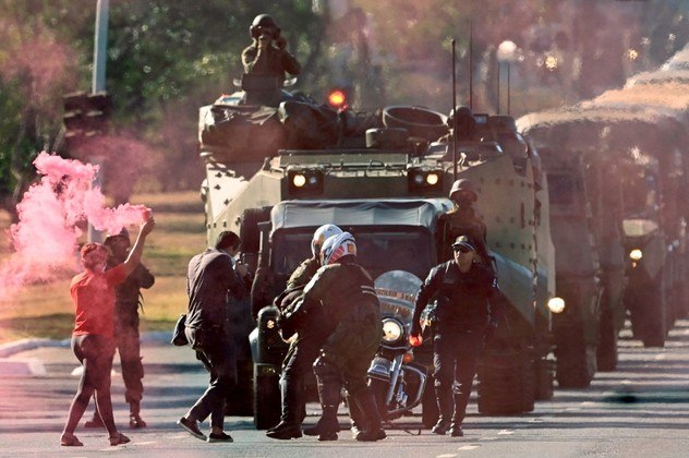 Militaries arrest protesters trying to block a military vehicles parade in front of the Planalto Palace in Brasilia, on August 10, 2021. Brazilian President Jair Bolsonaro is accused of using the armed forces for a show of force to intimidate National Congress, where a bill is being debated to modify the electronic voting system.
EVARISTO SA / AFP