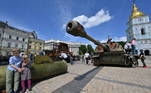 A exposição, a céu aberto, também contou com tanques russos capturados pelos ucranianos na guerra. Nesta imagem, dois meninos sentam-se em um míssil russo em Kiev