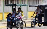 A Venezuelan family ride a traditional tricycle taxi in Maracaibo, Zulia State, Venezuela, on July 29, 2021. Franklin relies on the wind to power his small sailboat. Manuel, a former bus driver, carries passengers in a 'bicitaxi'. Both manage to survive the chronic fuel shortages in Zulia, the region that saw the birth of Venezuela's oil industry.
Luis BRAVO / AFP