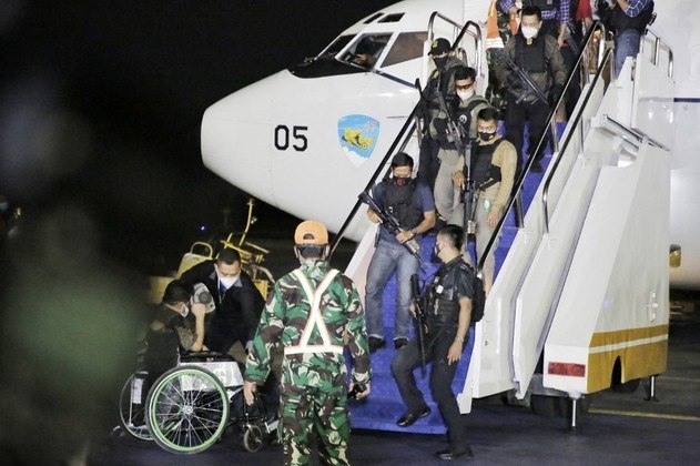 This handout picture taken and released on August 21, 2021 by Indonesia's Ministry of Foreign Affairs shows a wheelchair-bound man (bottom L) and armed personnel alighting from an Indonesian Air Force flight evacuation flight from Kabul transporting Indonesian embassy staff and their families, which includes two Afghan nationals, plus five Filipinos evacuated under the request of the Philippine government, following their arrival at Halim Airport in Jakarta.
Handout / MINISTRY OF FOREIGN AFFAIRS / AFP