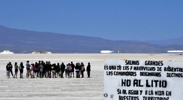 Um sinal contra a exploração de lítio é visto quando turistas visitam o salar de Salinas Grandes