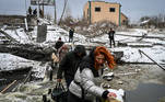 Civilians cross a river on a blown up bridge on Kyiv’s northern front on March 1, 2022. Defending capital Kyiv, the 'key priority' Ukrainian president said.
ARIS MESSINIS / AFP