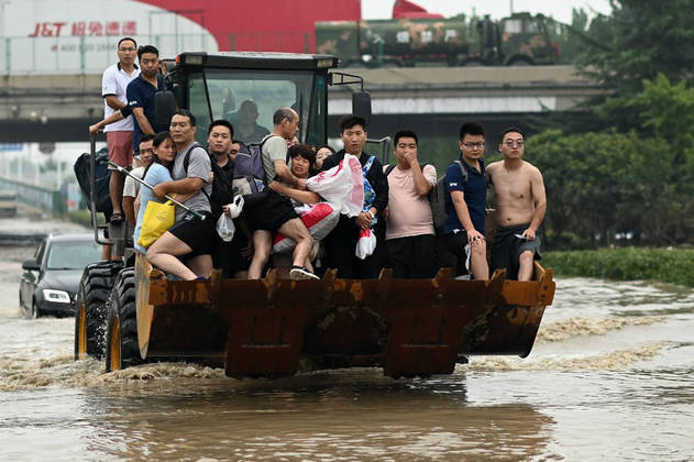 China-Weather-Flood
People ride in the front of a wheel loader to cross a flooded street following heavy rains which caused flooding and claimed the lives of at least 33 people earlier in the week, in the city of Zhengzhou in China's Henan province on July 23, 2021.
NOEL CELIS / AFP
