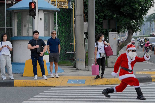 Tem Papai Noel em terra? Tem também. Esse da foto decidiu fazer uma apresentação em pleno trânsito em Manila, capital das Filipinas