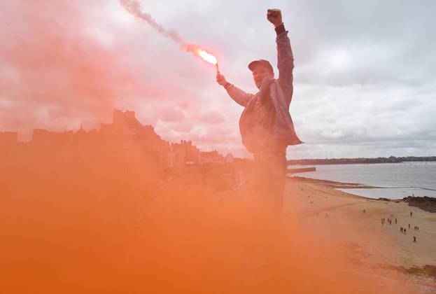 Em Saint-Malo, noroeste da França, esse manifestante usou um sinalizador para chamar a atenção. A reforma da previdência, que ampliou de 62 para 64 anos a idade mínima para se aposentar, aparece como pano de fundo das manifestações