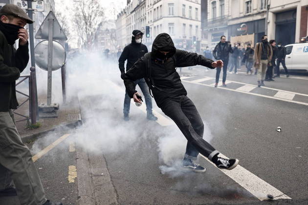 Em Lille, no norte do país, também há enfrentamento entre polícia e manifestantes. Nesta imagem, um rapaz chuta uma granada de gás de volta para as tropas militares durante uma manifestação 