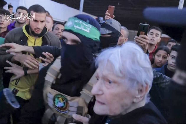 Havia seis senhoras, três mães e quatro crianças entre os israelenses libertados nesta sexta-feira. Na foto, uma das mulheres é conduzida por um terrorista da Brigada Al-Qassam, do Hamas, até integrantes da Cruz Vermelha, em Gaza, pouco antes da transferência para Israel 