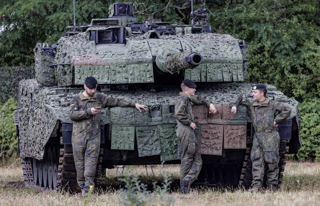 (FILES) This file photo taken on July 11, 2022 shows soldiers of the German Armed Forces (Bundeswehr) standing in front of a battle tank "Leopard" at the Digitalisation Unit of Land-Based Operations of the German Armed Forces (Bundeswehr) in Munster, northwestern Germany. Germany on January 25, 2023 approved the delivery of Leopard 2 tanks to Ukraine, after weeks of pressure from Kyiv and many allies. Berlin will provide a company of 14 Leopard 2 A6 tanks from the Bundeswehr stocks and is also granting approval for other European countries to send tanks from their own stocks to Ukraine, a government spokesman said in a statement.
