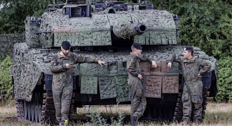 (FILES) This file photo taken on July 11, 2022 shows soldiers of the German Armed Forces (Bundeswehr) standing in front of a battle tank "Leopard" at the Digitalisation Unit of Land-Based Operations of the German Armed Forces (Bundeswehr) in Munster, northwestern Germany. Germany on January 25, 2023 approved the delivery of Leopard 2 tanks to Ukraine, after weeks of pressure from Kyiv and many allies. Berlin will provide a company of 14 Leopard 2 A6 tanks from the Bundeswehr stocks and is also granting approval for other European countries to send tanks from their own stocks to Ukraine, a government spokesman said in a statement.
