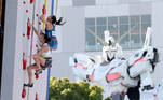 Japan's Akiyo Noguchi (top) and Slovenia's Mia Krampl (lower) compete in the women's sport climbing speed qualification while Japanese animation's life-size robot, 'Unicorn Gandam' (R) look on during the Tokyo 2020 Olympic Games in Tokyo on August 04, 2021.
STR / JIJI PRESS / AFP
