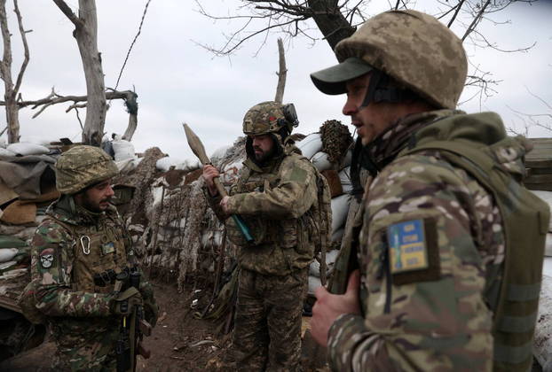 Ukrainian servicemen examine an RPG rocket as they stand in a trench on a frontline position in the Donetsk region on January 23, 2023, amid the Russian invasion of Ukraine.