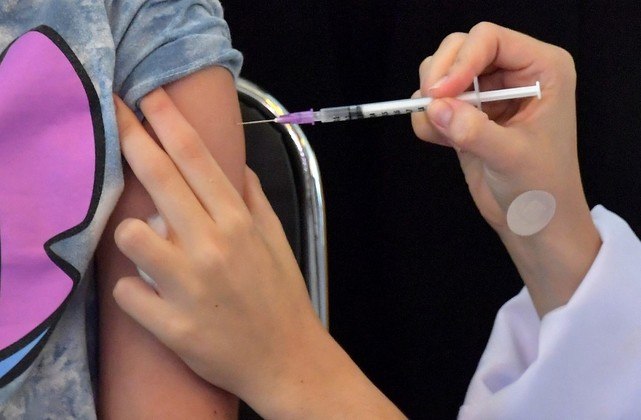 A girl receives the first dose of the Pfizer-BioNTech vaccine against COVID-19, at the Clinicas hospital in Sao Paulo, Brazil, on January 14, 2022.
NELSON ALMEIDA / AFP