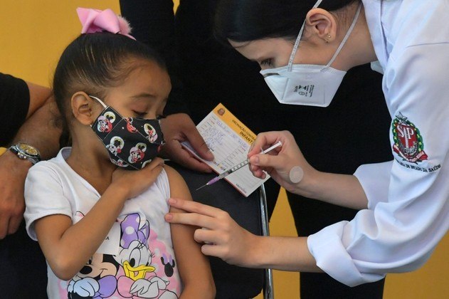 A girl receives the first dose of the Pfizer-BioNTech vaccine against COVID-19, at the Clinicas hospital in Sao Paulo, Brazil, on January 14, 2022.
NELSON ALMEIDA / AFP