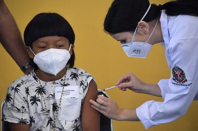 Brazilian indigenous boy Davi Xavante -the first child in Brazil to get vaccinated against COVID-19- receives the first dose of the Pfizer-BioNTech vaccine at the Clinicas hospital in Sao Paulo, Brazil, on January 14, 2022.
NELSON ALMEIDA / AFP