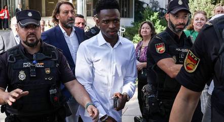 Vini Jr. chega para depor com advogado e ajuda policial