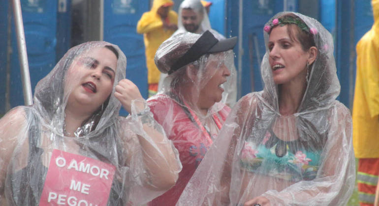 A capa de chuva virou um item obrigatório para os foliões acompanharem o Agrada Grego nas ruas de São Paulo