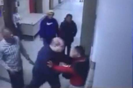 Policial aparece empurrando rapaz contra parede