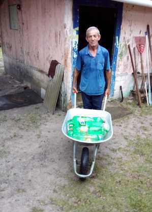 Moradores usam carrinho de mão para buscar água em garrafas pet