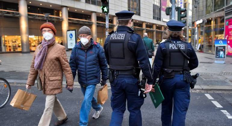 Policiais caminham por uma rua comercial em meio à pandemia da Covid-19 na Alemanha
