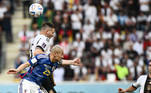 Niklas Suele e Daizen Maeda disputam a bola na partida entre Alemanha e Japão na Copa