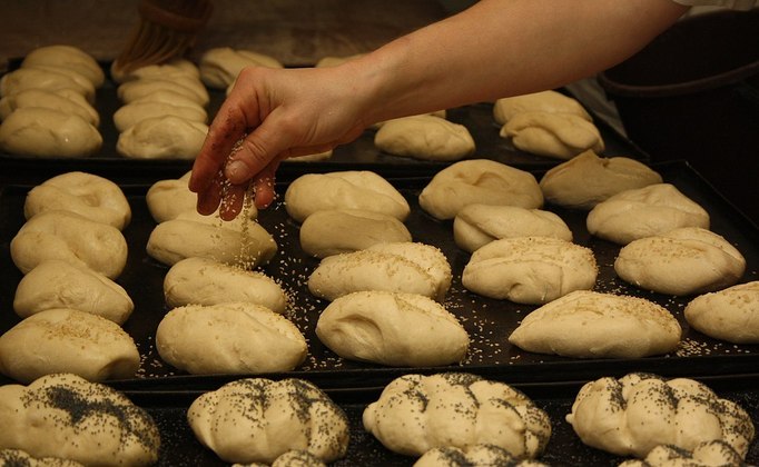Algumas vezes, o pãozinho leva acréscimos de gergelim ou grãos, colocados antes do forno. 
