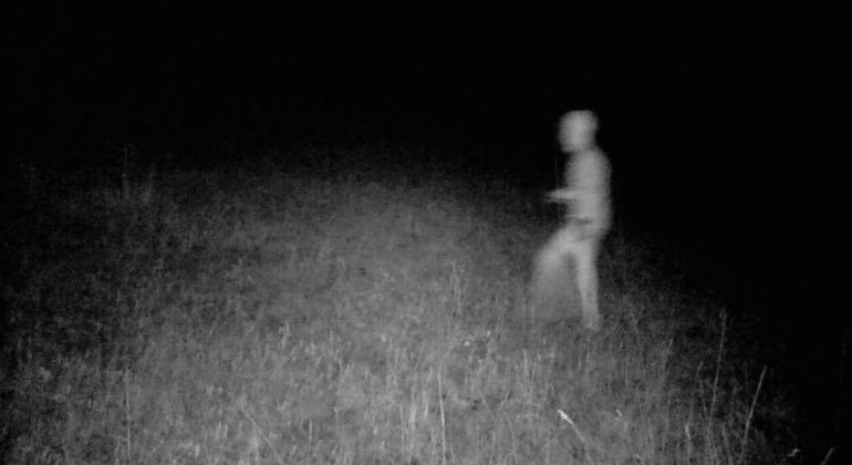 Imagem mostra um ser estranho caminhando na frente de uma câmera de caça noturna