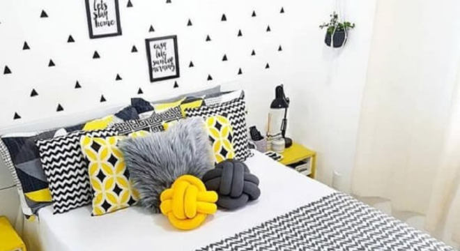 Almofada de nó em tons de cinza e amarelo se misturam com a decoração do ambiente