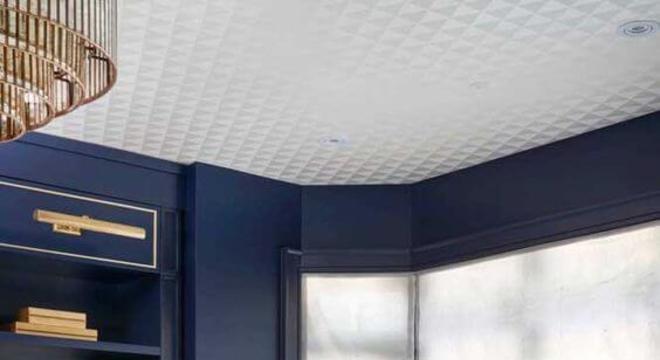 Almofadas em rosa claro para contrastar com a parede azul marinho