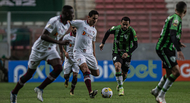 Paulo Henrique Ganso, do Fluminense, acompanhado no meio-campo por Felipe Azevedo, do América-MG