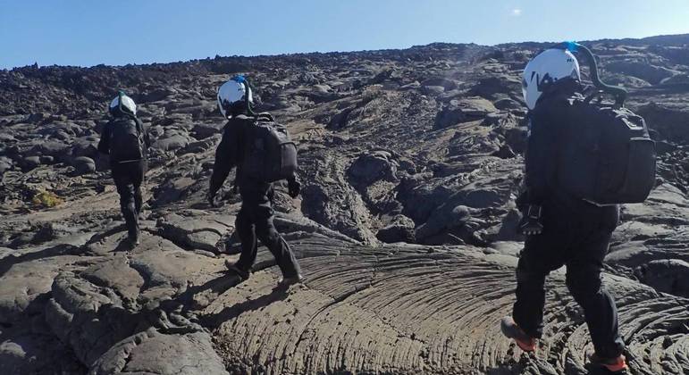 Ana Paula e seus colegas caminhando sobre o vulcão