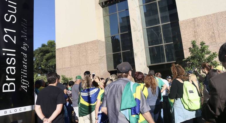 Apoiadores aguardam a chegada do ex- presidente Jair Bolsonaro em frente à sede do PL, em Brasília